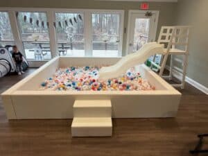 Indoor ball pit with slide for kids' entertainment at Premier Party Rental.